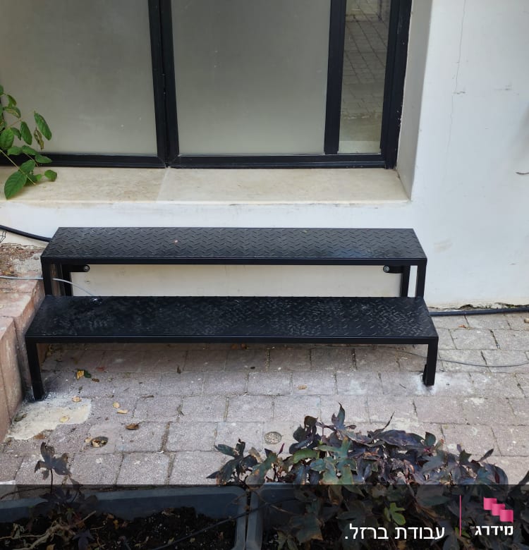 מסגרת חלון שחורה עם מדרגות מתכת שחורות